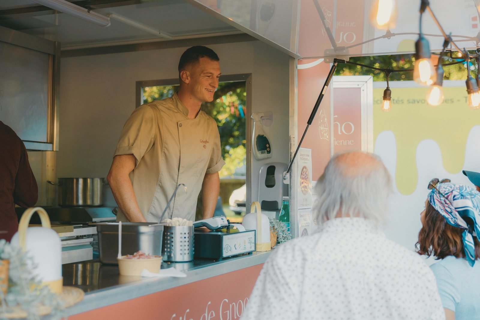 Le camion Gnoccho, un membre de l'équipe servant des clients